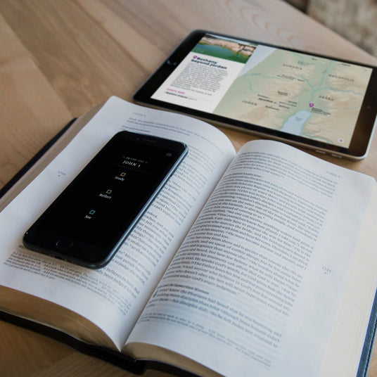 Open Filament Enabled Bible with mobile phone and table showing extra content